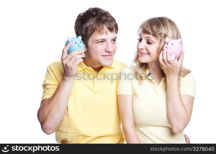 A young couple listening to their piggy banks, can be used for finance or saving concept