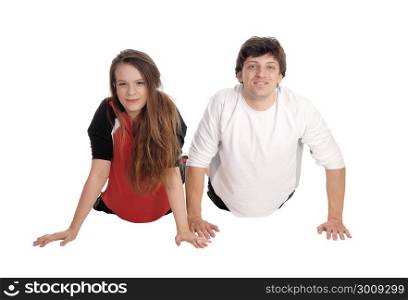 A young couple lying on the floor side by side and exercising inpunch-up?s, smiling, isolated for white background