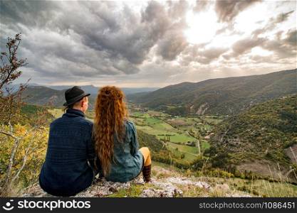 a young couple of lovers looking the mountain