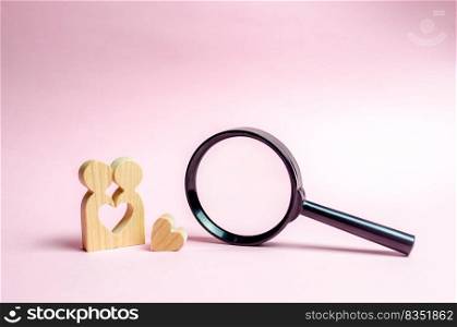 A young Couple of lovers of lovers are standing near to a magnifying glass. concept of finding a couple on Valentine’s Day. Declaration of love and the creation of strong love relationships. Dating