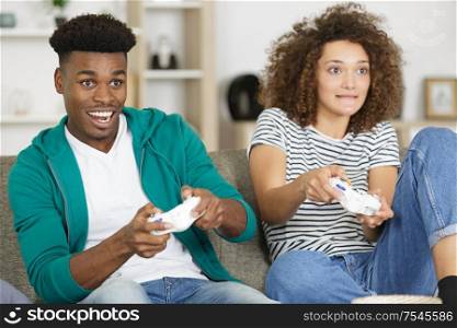 a young couple on the sofa playing video game