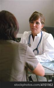a young doctor with a stethoscope. in an interview with a patient