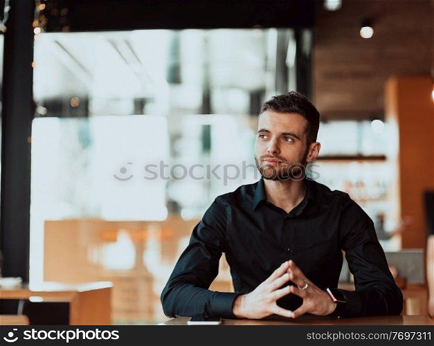 a young entrepreneur sits in a cafe and thinks of new business ideas. Business concept. a young entrepreneur sits in a cafe and thinks of new business ideas.