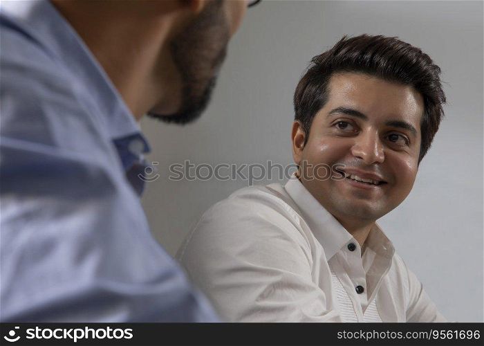 A YOUNG EXECUTIVE TALKING TO COLLEAGUE IN OFFICE