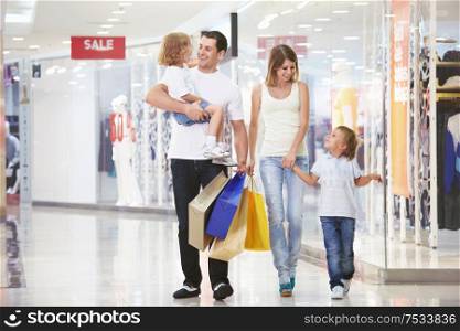 A young family of four with children in the store