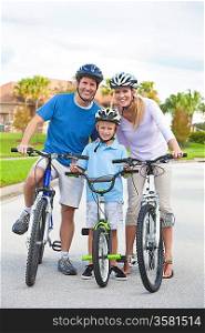 A young family of man and woman parents and one boy child, cycling together.