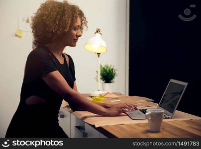 A young fashion designer on her atelier working with a laptop