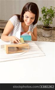 A young female architect testing a color swatch on a model house