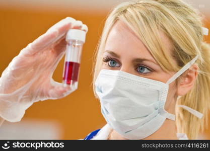 A young female doctor/nurse looking at a blood sample