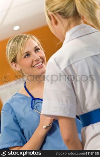 A young female doctor with her female nursing colleague out of focus in the foreground