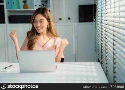 A young female employee receives a promotion, good news or finished her task and overjoyed for being a competent worker.. A young female employee receives a promotion for being a competent worker.