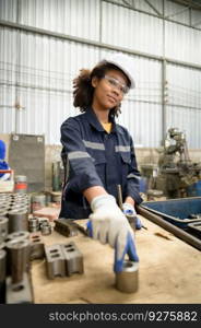 A young female engineer inspects and repairs parts of a robotic welding machine to make it work normal operation.