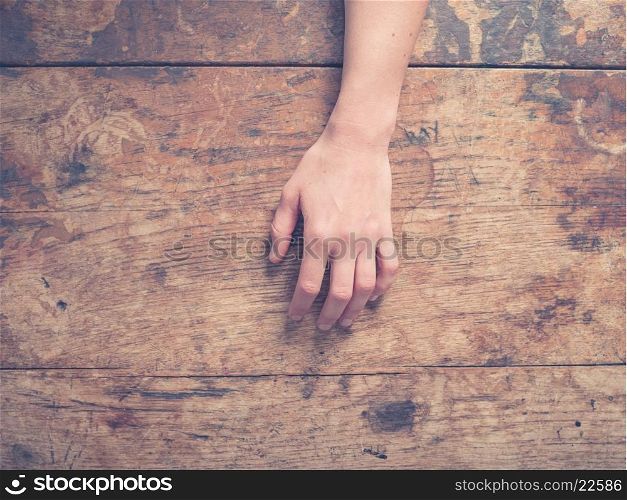 A young female hand on a wooden table