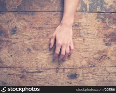 A young female hand on a wooden table