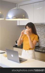 A young female working with her laptop and having a cup of coffee, life style and business concept. Young female working with her laptop and having a cup of coffee, life style and business concept
