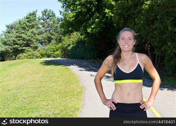 A young, fit caucasian woman along a jogging trail