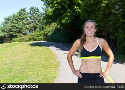 A young, fit caucasian woman along a jogging trail