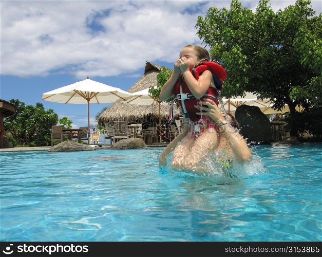 A young girl (12-13) with her father in water, Moorea, Tahiti, French Polynesia, South Pacific
