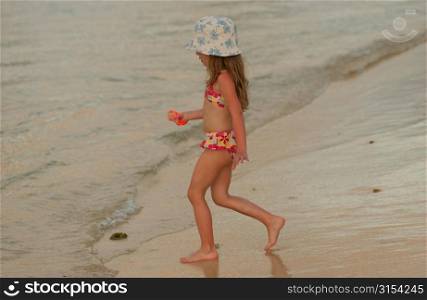 A young girl (6-8) on a beach, Moorea, Tahiti, French Polynesia, South Pacific