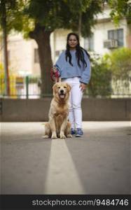 A YOUNG GIRL AND PET DOG LOOKING AT CAMERA AND POSING