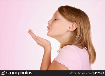 a young girl blowing a kiss on pink