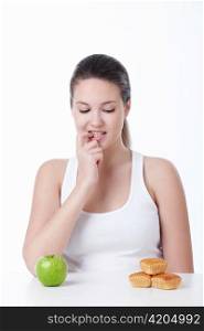A young girl chooses between a healthy diet and sweet on a white background