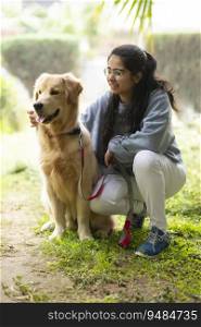 A YOUNG GIRL HAPPILY SITTING WITH HER PET DOG DURING A WALK