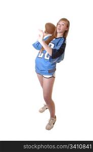 A young girl in a blue football outfit standing in the studio and show howto play football, for white background.