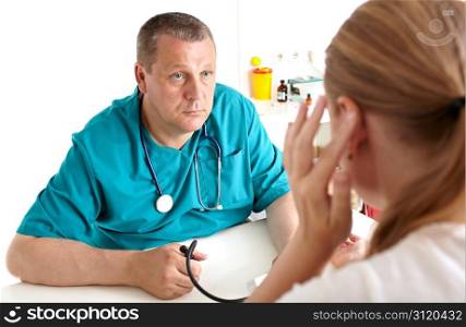 A young girl is complaining of headaches. A light medical study. The doctor of 45-50 years old in a green smock. Caucasian. Shallow depth of field. Focus is on the doctor. Shallow dof.