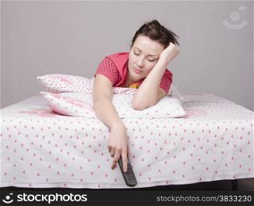 A young girl is Watching TV in bed