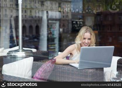 A young girl looks into the laptop in a cafe