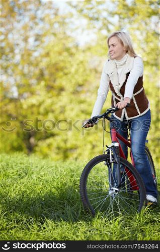 A young girl on a bicycle in the autumn park