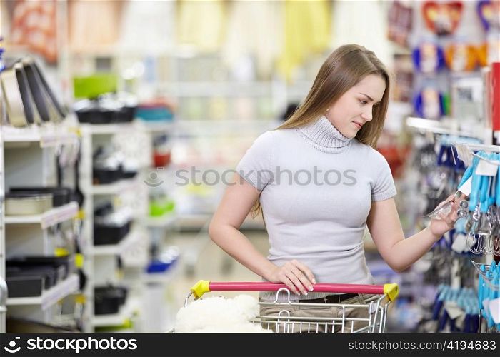 A young girl picks the goods in the shop