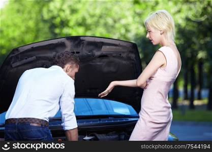 A young girl scolds the young guy behind the car broke down