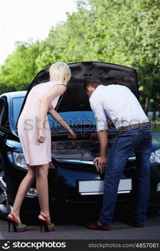 A young girl shows men how to repair cars