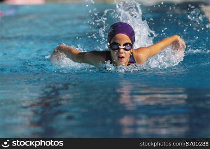 A young girl swimming in a pool
