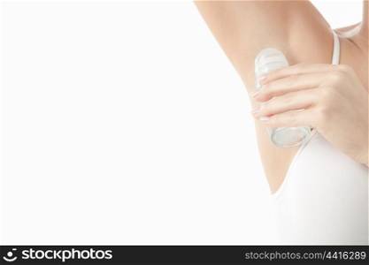 A young girl uses deodorant isolated