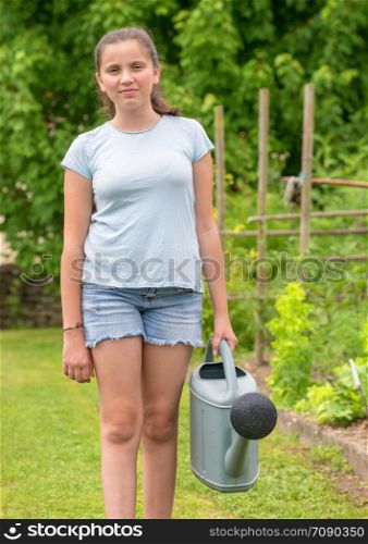 a young girl with a watering can in the garden