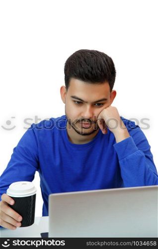 a young guy sitting at a laptop in search of work on the Internet , doing business in the global network with a Cup of coffee. on light background