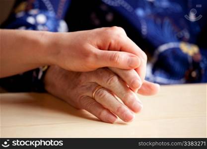 A young hand comforts and elderly hand