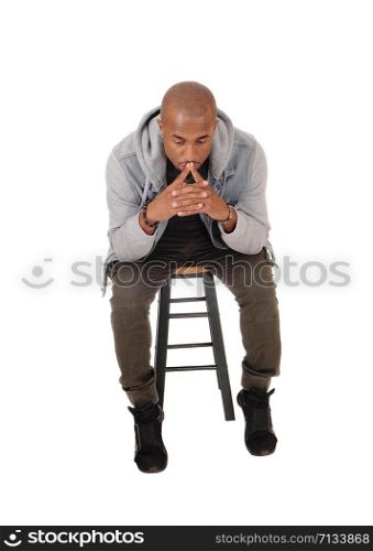 A young handsome African American man sitting on a chair with his fingers on his mouths, thinking, isolated for white background