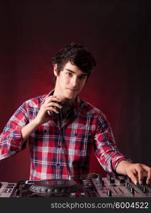 A young handsome deejay boy playing some music