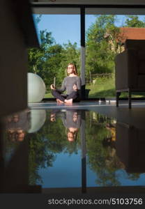 A young handsome woman doing yoga exercises on the floor of her luxury home villa