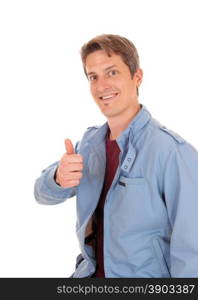 A young happy man in a blue jacket standing for white backgroundwith his thump up and smiling.