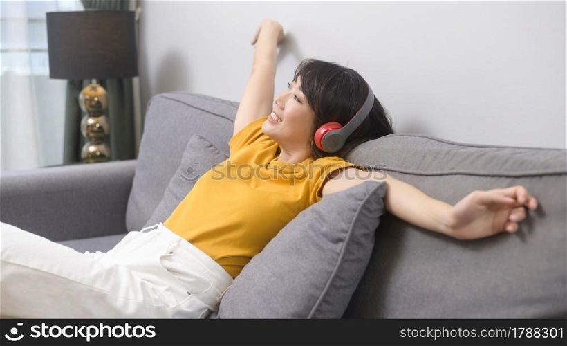 A young happy woman listening to music and relaxing at home. Young happy woman listening to music and relaxing at home