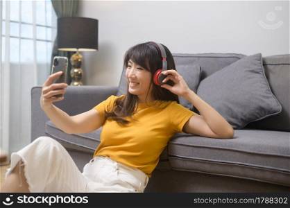 A young happy woman listening to music and relaxing at home. Young happy woman listening to music and relaxing at home
