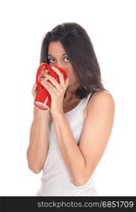 A young Hispanic woman in a white t-shirt holding a red coffeemug on her mouth, isolated for white background.