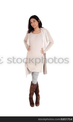 A young Hispanic woman standing from the front in a knitted dress and brown boots, isolated for white background.