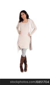 A young Hispanic woman standing from the front in a knitted dress and brown boots, isolated for white background.
