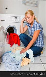 a young housewife with washing machine and clothes. laundry day.